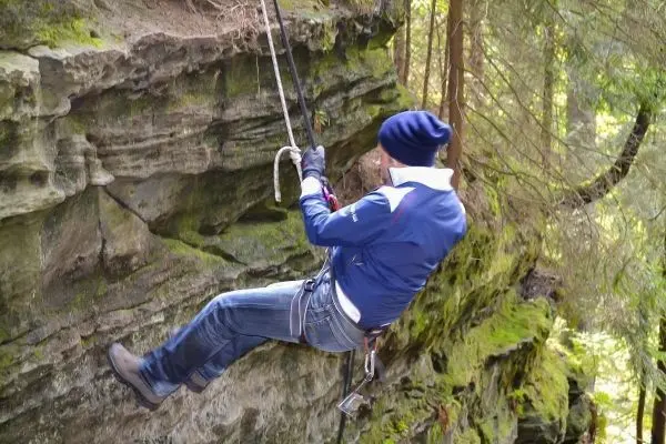 Abseilen an einer Felswand mit Seil und Kletterausrüstung