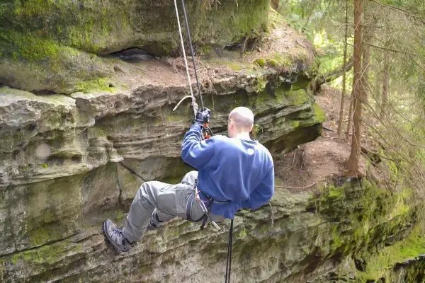 Abseilen an einer Felswand mit Seil und Sicherungsgerät