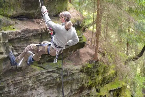 Abseilen an einer Felswand mit Sicherungsgerät und Seil