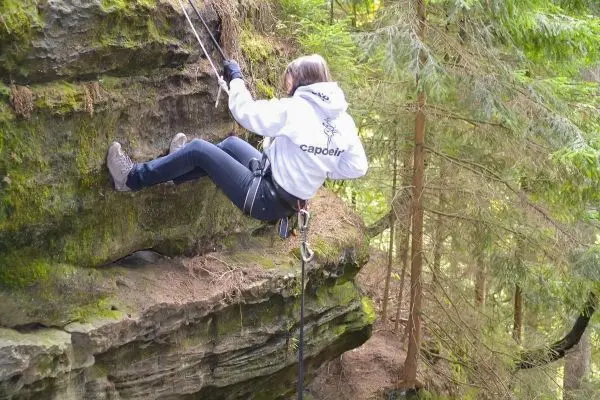 Abseilen an einer Felswand mit Sicherungshaken und Seil