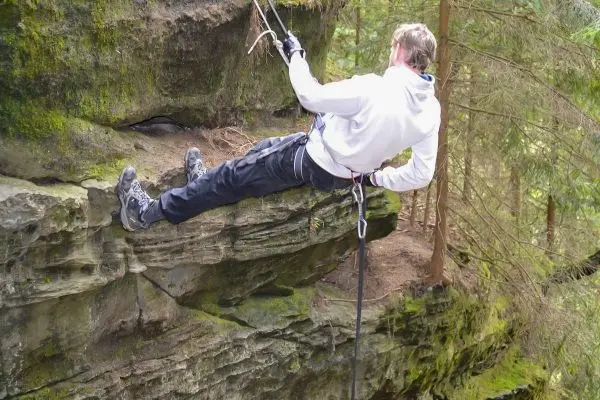 Abseilen an einer Felswand mit Sicherungsseil und Karabiner