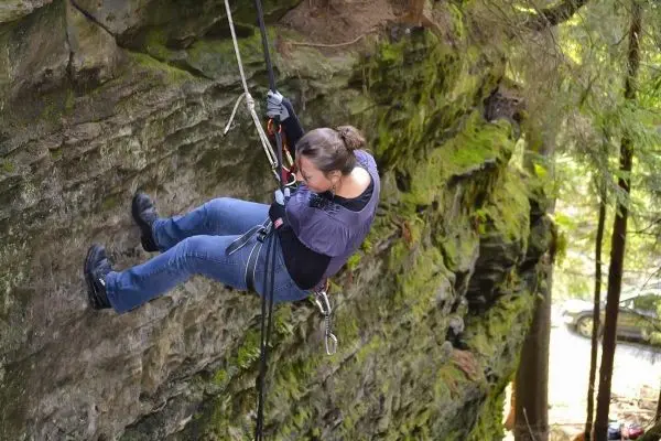 Abseilen an einer steilen Felswand mit Sicherungsseil und Kletterausrüstung