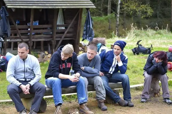 Bänke mit mehreren Personen, die in einer Gruppe sitzen und nachdenklich wirken