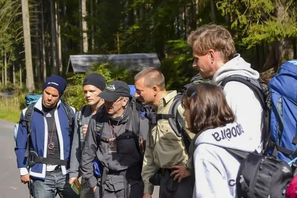 Gruppe mit Rucksäcken betrachtet Karte in einem Waldgebiet