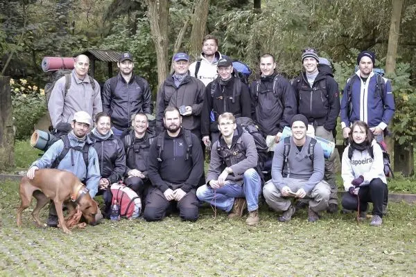Gruppe von Personen mit Rucksäcken und einem Hund im Freien