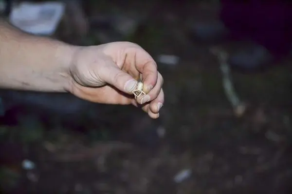 Hand hält einen kleinen Gegenstand mit einer metallischen Oberfläche