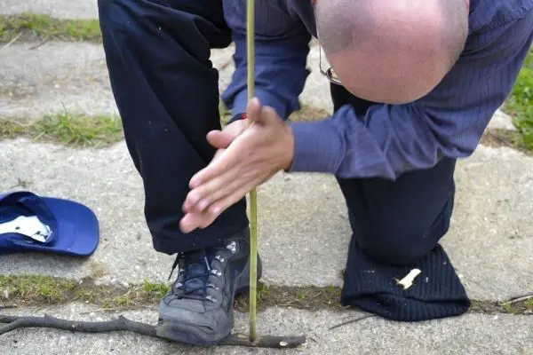 Holzstück wird mit einem Stock bearbeitet, um Reibung zu erzeugen