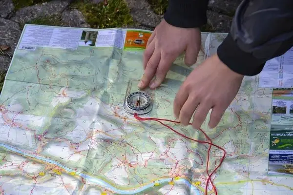 Kompass wird auf einer Landkarte positioniert, um die Orientierung zu bestimmen