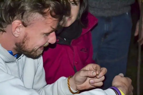 Mann hält einen kleinen Gegenstand in der Hand und konzentriert sich darauf