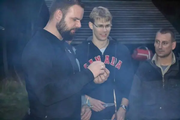 Mann hält Zunder in der Hand, während Rauch um ihn herum aufsteigt