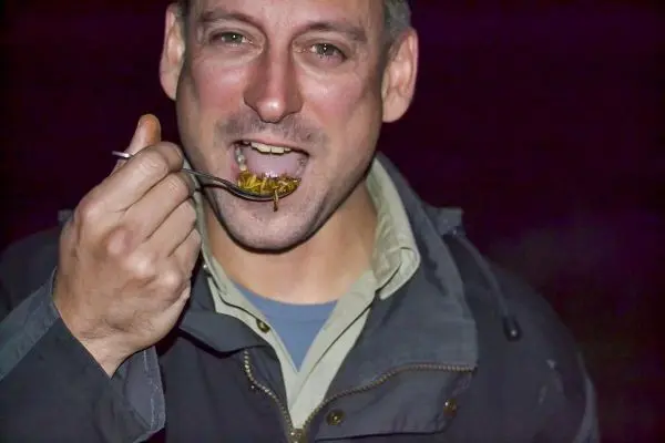 Mann isst mit einem Löffel eine Portion Nahrung