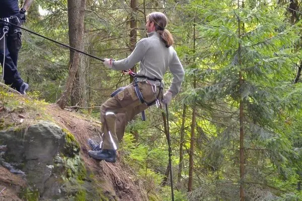 Person sichert sich mit Seil an einem Hang ab