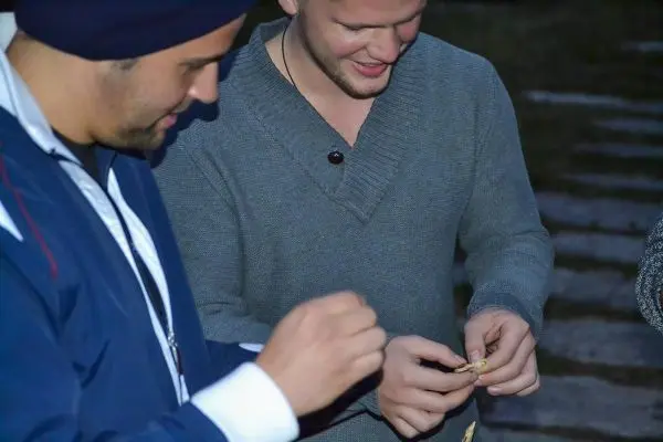 Zwei Personen halten kleine Gegenstände in den Händen und interagieren miteinander