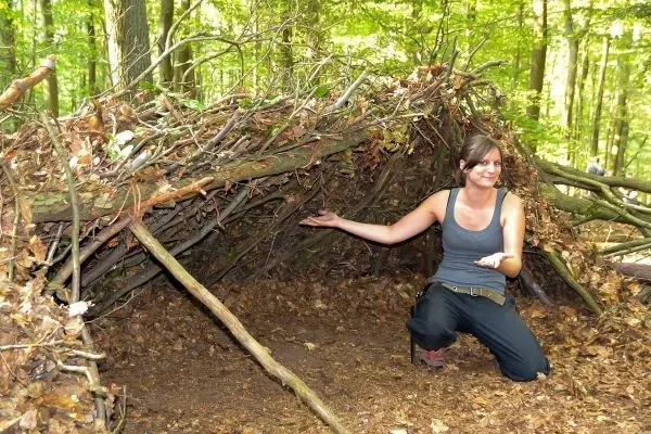 Selbstgebaute Laubhütte aus Ästen und Blättern im Wald