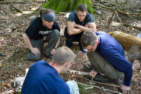 Vier Personen arbeiten gemeinsam an einem Projekt im Wald