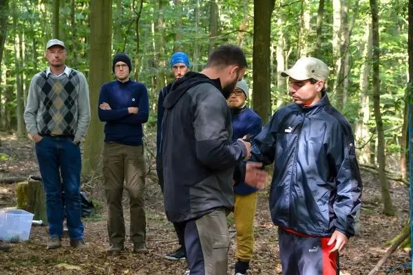 Zwei Personen schütteln sich die Hände, während andere im Hintergrund beobachten