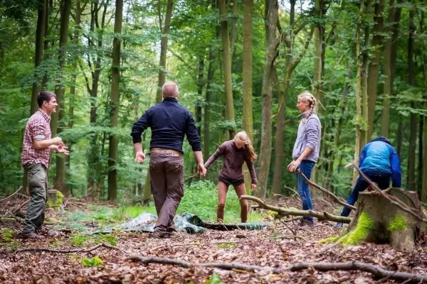 Gruppe arbeitet an einer Tarp-Notunterkunft im Wald