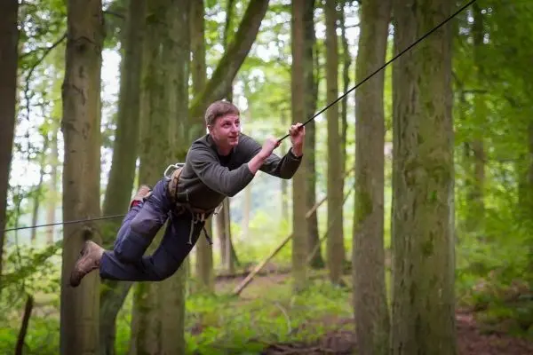 Selbstgebaute Seilquerung wird von einer Person überquert