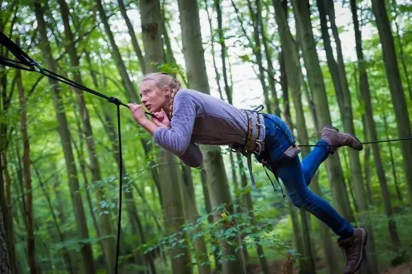 Überquert eine selbstgebaute Seilbrücke zwischen Bäumen