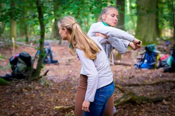 Zwei Personen üben eine Technik zur Befreiung aus einer Umklammerung im Wald