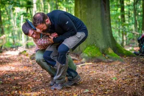 Zwei Personen üben eine Technik zur Kontrolle in einem Waldgebiet