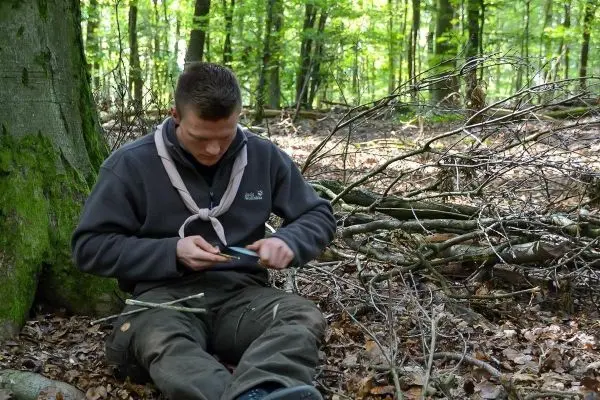 Messer schneidet Holzstück in einem Waldgebiet