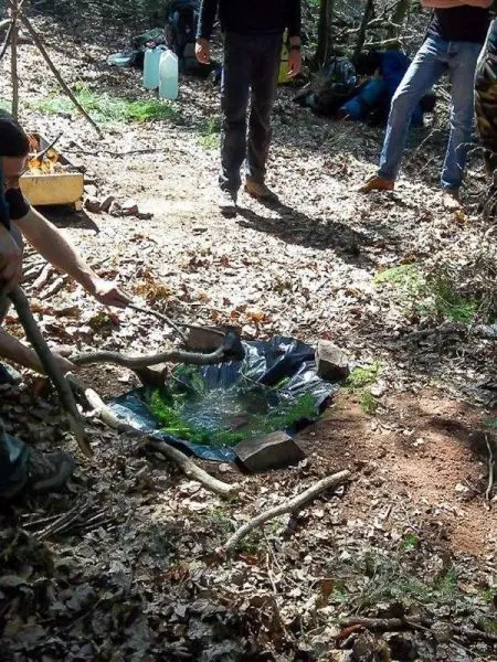 Wasser wird mit einem improvisierten Schichtfilter aus Ästen und Folie gereinigt