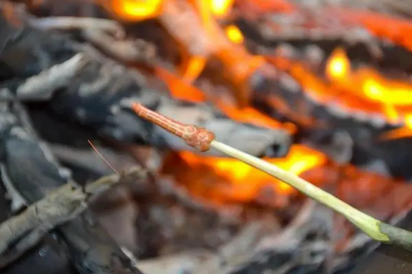 Zunder glimmt über kleiner Flamme im Feuer