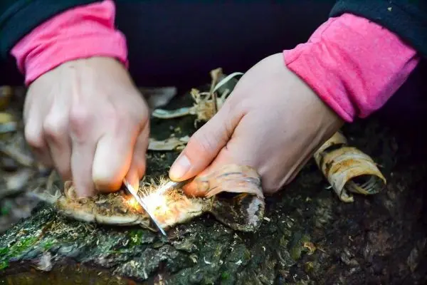 Feuerstahl erzeugt Funken auf Zunder aus Rinde