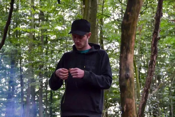 Zunder wird in der Hand gehalten, während Rauch im Hintergrund aufsteigt