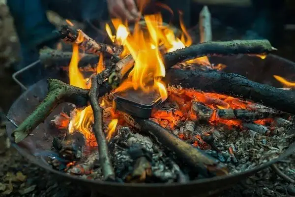 Feuer brennt in einer Feuerschale mit Holzstücken