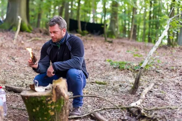 Kleinfeuer brennt auf einem Holzstück im Wald
