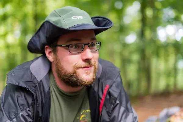 Person sitzt im wald und schaut nachdenklich