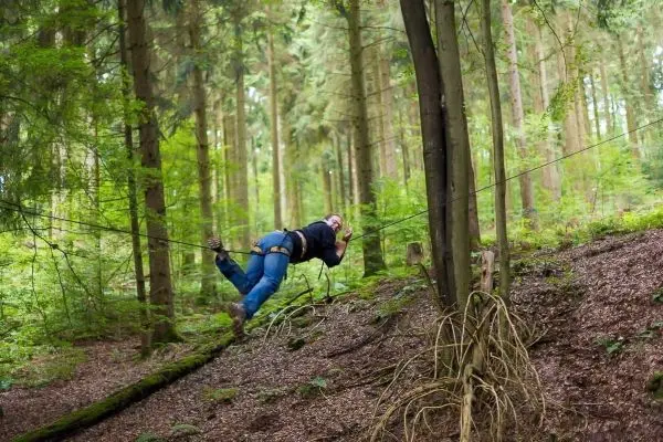 Selbstgebaute Seilquerung wird von einer Person überquert