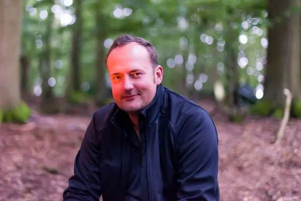 Sitzende Person in einem Wald mit unscharfem Hintergrund