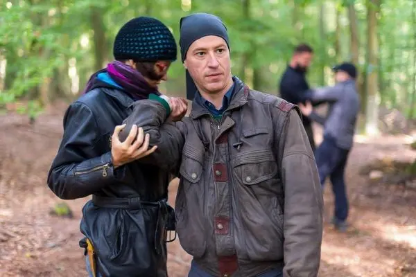 Zwei Personen üben eine Selbstverteidigungstechnik im Wald