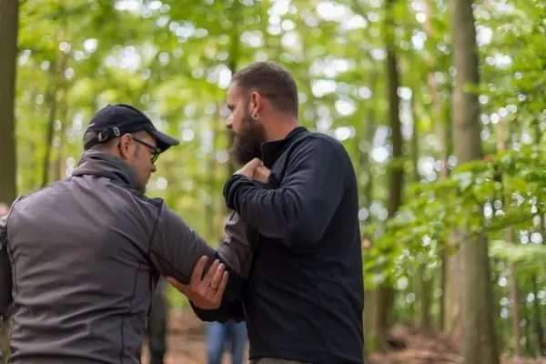 Zwei Personen üben eine Technik zur Kontrolle im Wald