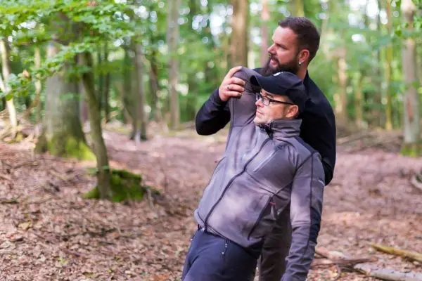 Zwei Personen üben eine Technik zur Selbstverteidigung im Wald