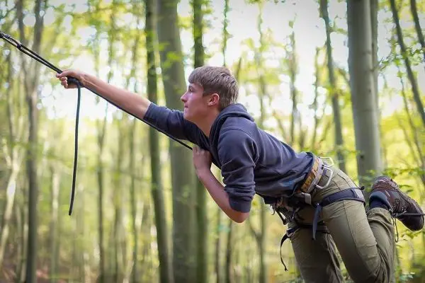 Person zieht an einem Seil im Wald