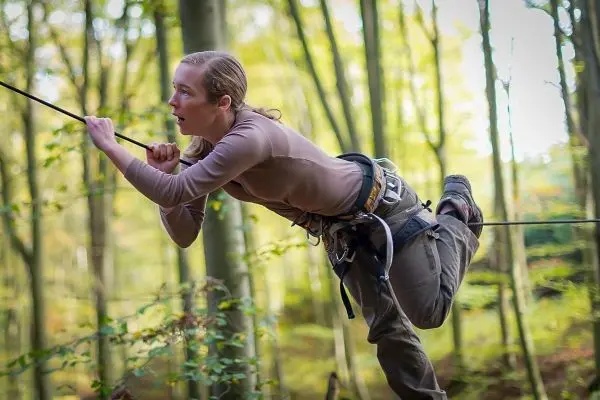 Seilquerung mit Klettergurt und Seil im Wald