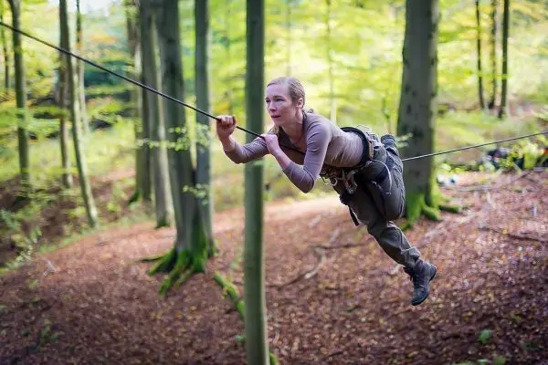 Seilquerung zwischen Bäumen mit gesichertem Gurtzeug und Seil