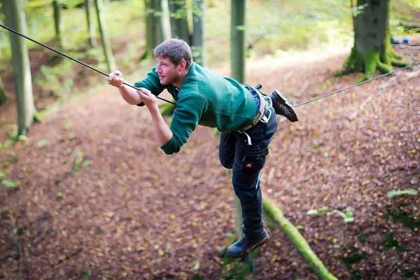 Selbstgebaute Seilquerung wird von einer Person überquert