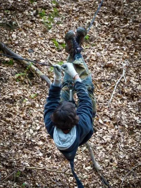 Seilquerung über Laubboden mit gesicherten Füßen und Händen