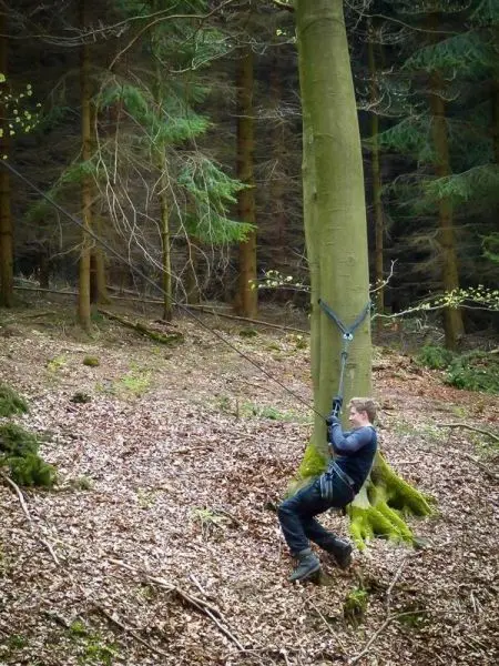 Selbstgebaute Seilquerung über einen Baumstamm im Wald
