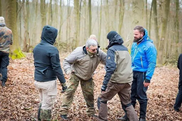 Gruppendynamik im Wald, Teilnehmer in unterschiedlichen Outfits interagieren