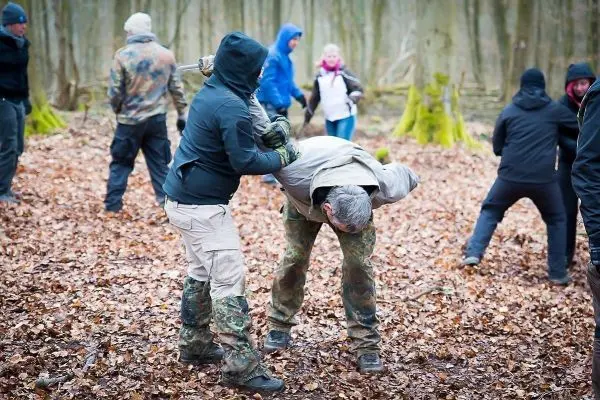 Kampftraining im Wald mit mehreren Teilnehmern in unterschiedlichen Positionen