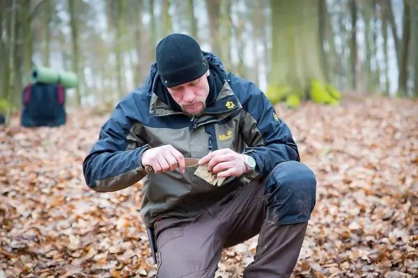 Messer bearbeitet Holzstück im Laubwald