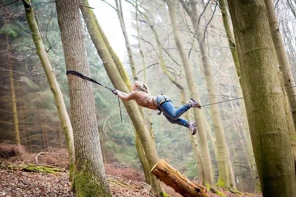 Selbstgebaute Seilquerung zwischen zwei Bäumen wird überquert