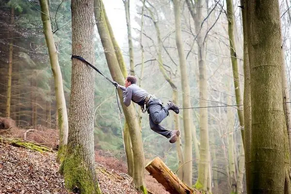 Selbstgebaute Seilquerung zwischen zwei Bäumen wird überquert