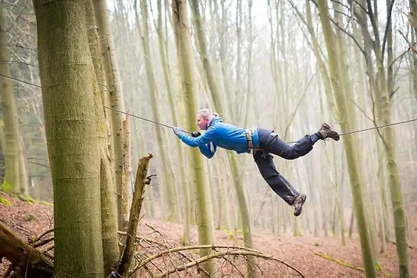 Selbstgebaute Seilquerung zwischen zwei Bäumen wird überquert